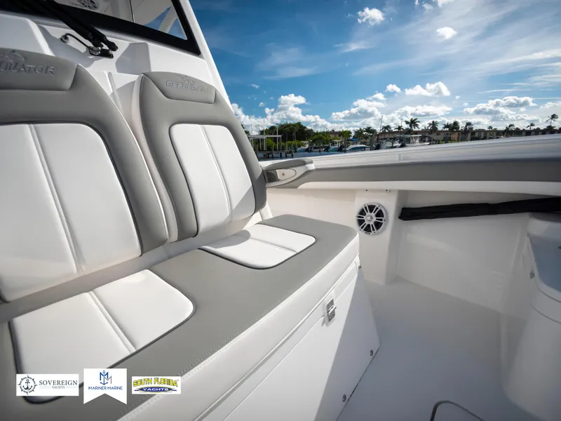 Slide: The Image of 2024 Regulator 28 boat interior with cushioned seating and scenic water view. - 23