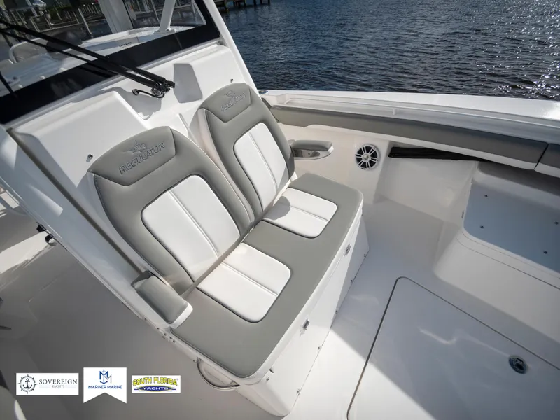Slide: The Image of 2024 Regulator 28 boat interior with dual cushioned seats, white and gray design. - 24