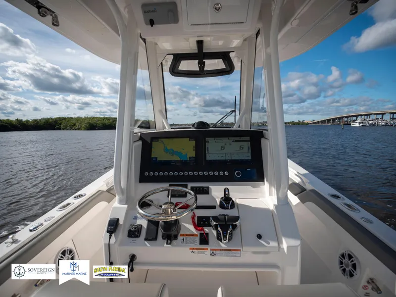 Slide: The Image of 2024 Regulator 28 boat dashboard with navigation screens on a sunny day. - 27