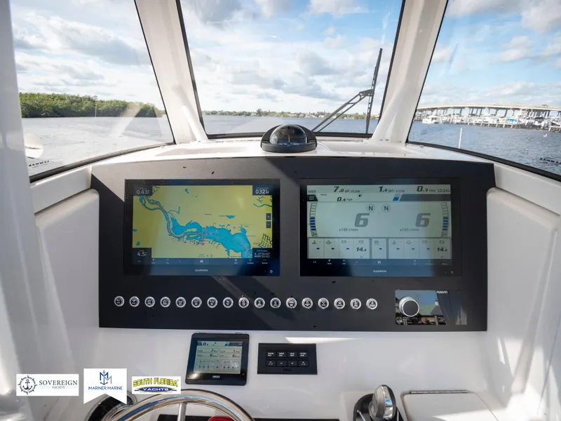 Slide: The Image of 2024 Regulator 28 boat dashboard with navigation screens and controls on a sunny day. - 28
