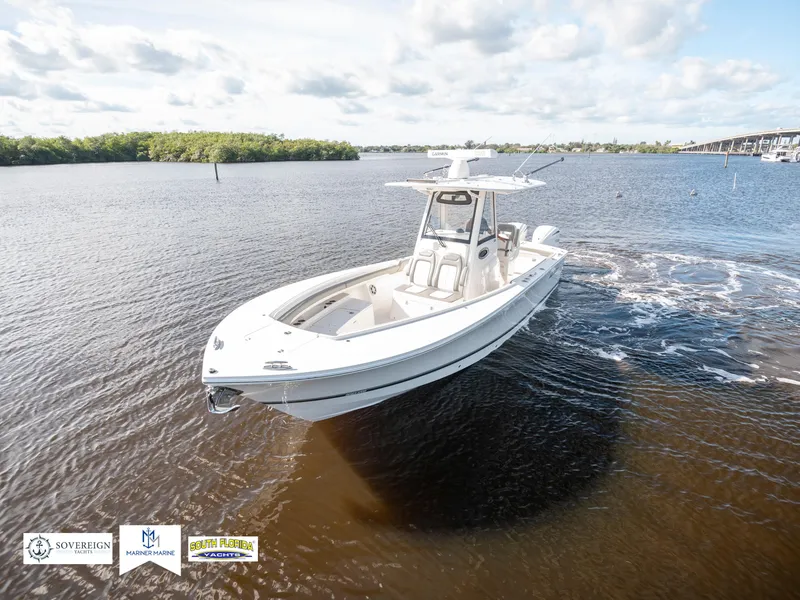 Slide: The Image of 2024 Regulator 28 boat cruising on a calm lake under a partly cloudy sky. - 3