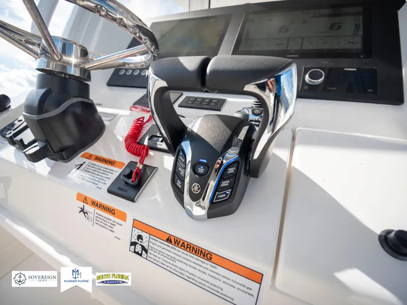 Slide: The Image of 2024 Regulator 28 boat helm with modern controls and warning labels. - 33