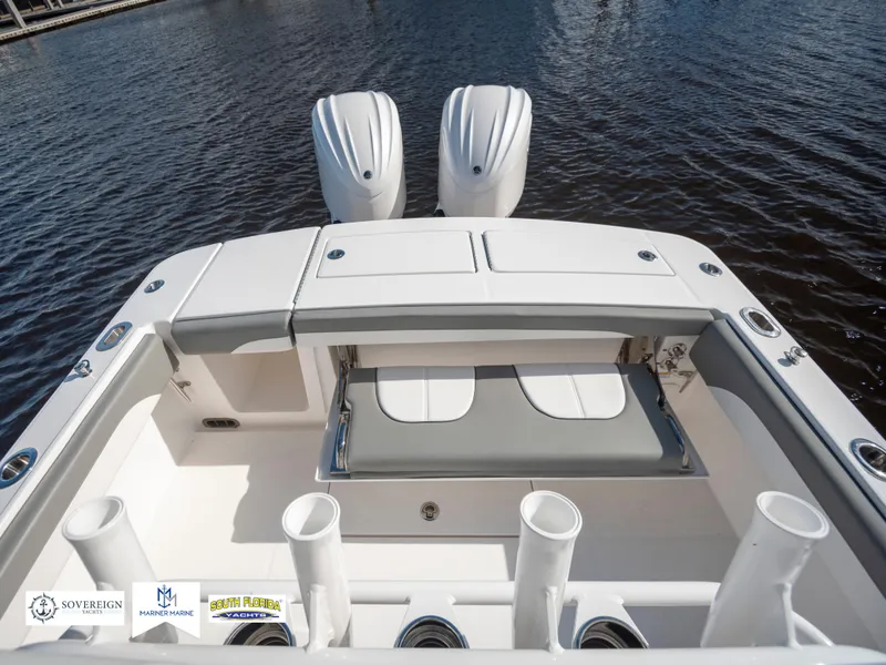 Slide: The Image of 2024 Regulator 28 boat with dual engines, spacious deck, and rod holders on water. - 40