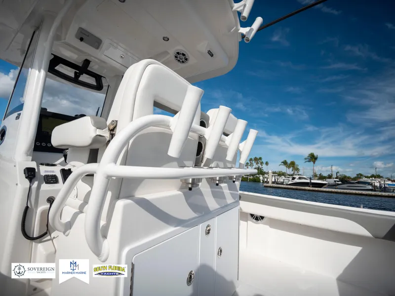 Slide: The Image of 2024 Regulator 28 boat interior with rod holders and storage, under a clear blue sky. - 42