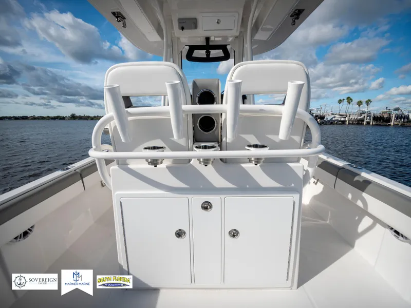 Slide: The Image of 2024 Regulator 28 boat interior with dual seats and storage, overlooking a scenic waterfront. - 43