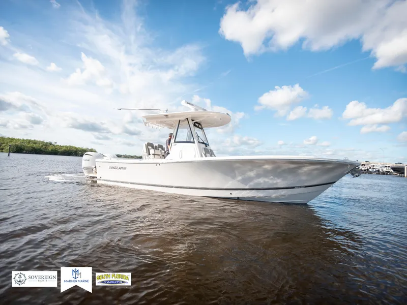 Slide: The Image of 2024 Regulator 28 boat cruising on a sunny day with blue skies and clouds. - 7