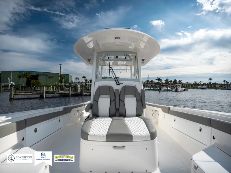 Slide: The Image of 2024 Regulator 30XO boat with sleek seating, docked by a scenic waterfront. - 12