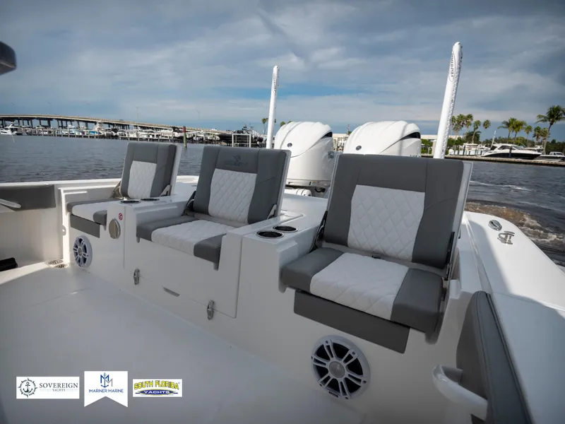 Slide: The Image of 2024 Regulator 30XO boat interior with plush seating and dual engines, docked by the marina. - 15