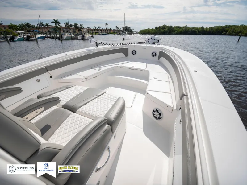 Slide: The Image of 2024 Regulator 30XO boat with luxurious seating on a calm waterfront. - 17