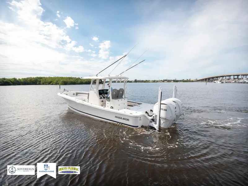 Slide: The Image of 2024 Regulator 30XO boat cruising on a calm river under a clear sky. - 2