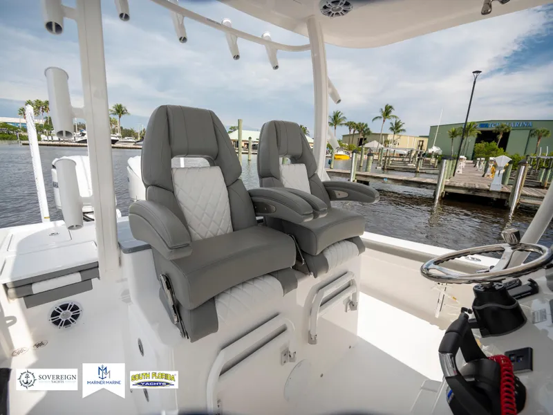 Slide: The Image of 2024 Regulator 30XO boat with luxurious seating and modern helm, docked by the water. - 25