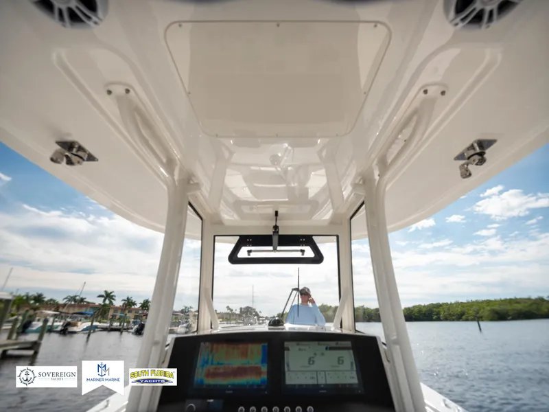 Slide: The Image of 2024 Regulator 30XO boat interior with navigation system, docked by a scenic waterfront. - 28