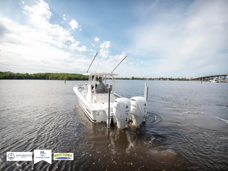 Slide: The Image of 2024 Regulator 30XO boat cruising on a calm river under a clear sky. - 3
