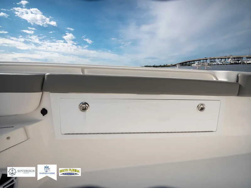 Slide: The Image of 2024 Regulator 30XO boat interior with storage compartment and scenic sky background. - 37