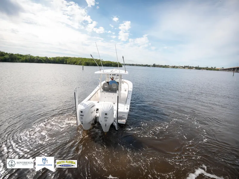 Slide: The Image of 2024 Regulator 30XO boat cruising on a calm river under a clear sky. - 4