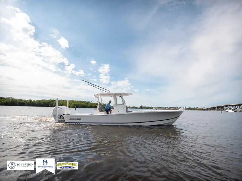 Slide: The Image of 2024 Regulator 30XO boat cruising on a calm river under a clear sky. - 6