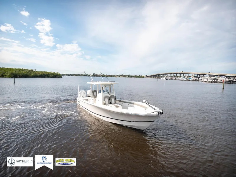 Slide: The Image of 2024 Regulator 30XO boat cruising on a calm river under a clear sky. - 7