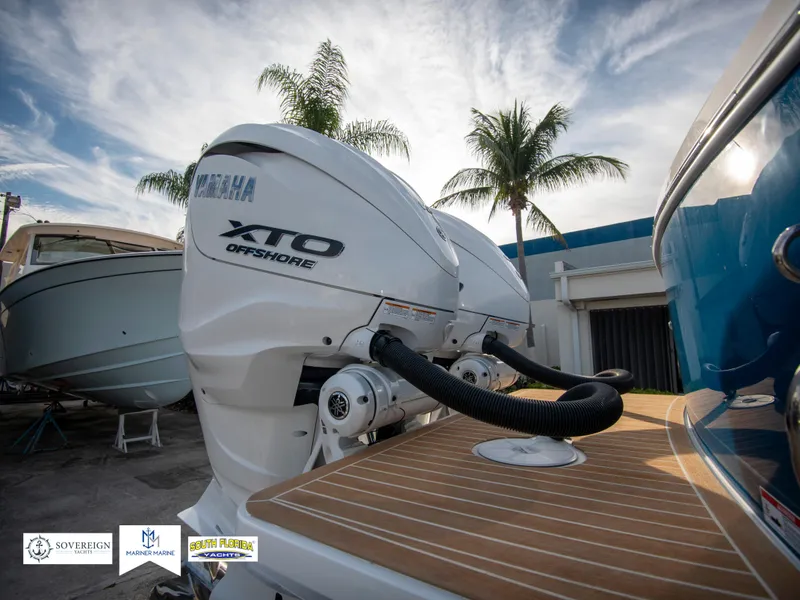 Slide: The Image of 2024 Regulator 31 boat with Yamaha XTO Offshore engines, docked under palm trees. - 11