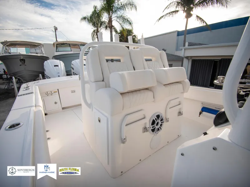 Slide: The Image of 2024 Regulator 31 boat interior with white seating and palm trees in the background. - 33