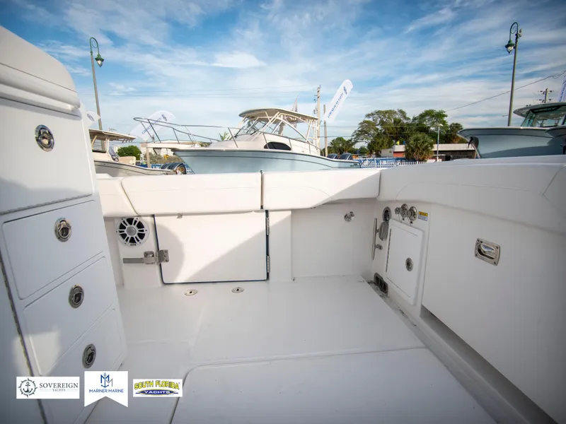 Slide: The Image of 2024 Regulator 31 boat interior with storage compartments and docked boats in the background. - 38