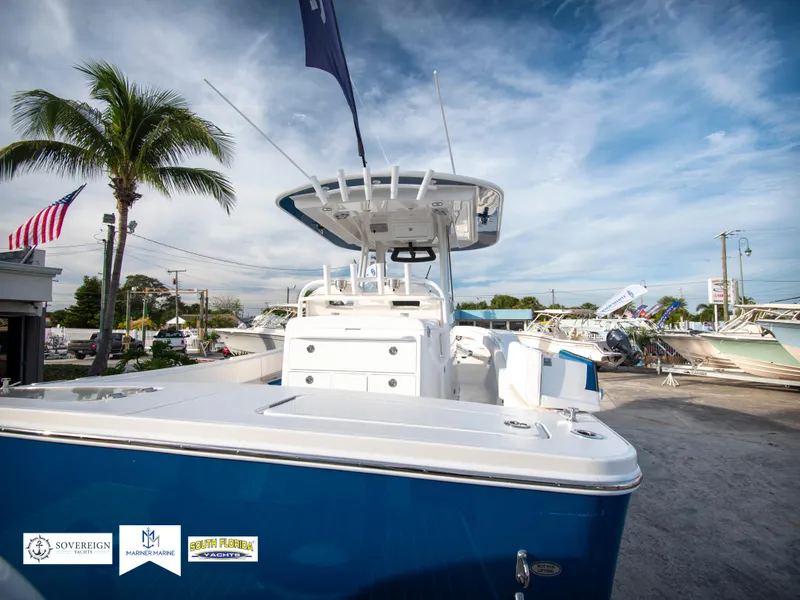 Slide: The Image of 2024 Regulator 31 boat displayed outdoors with palm trees and American flag. - 9