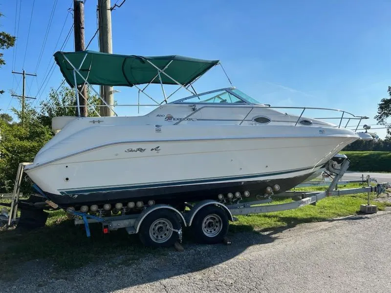 The Image of 1997 Sea Ray Sundancer boat on a trailer with green canopy. - 1