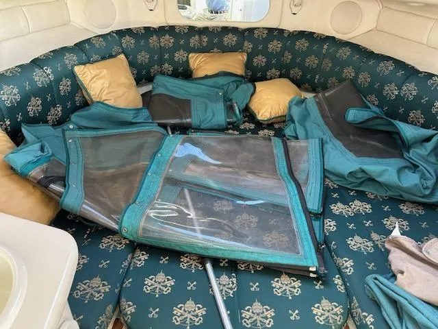 Slide: The Image of Interior of 1997 Sea Ray Sundancer with teal upholstery and folded canvas covers. - 8