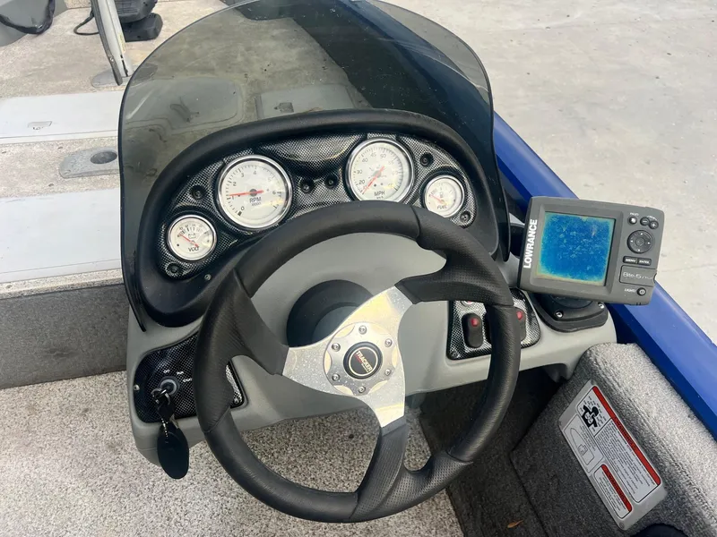 Slide: The Image of 2013 Tracker Pro Team 175 TF boat dashboard with steering wheel and fish finder. - 8
