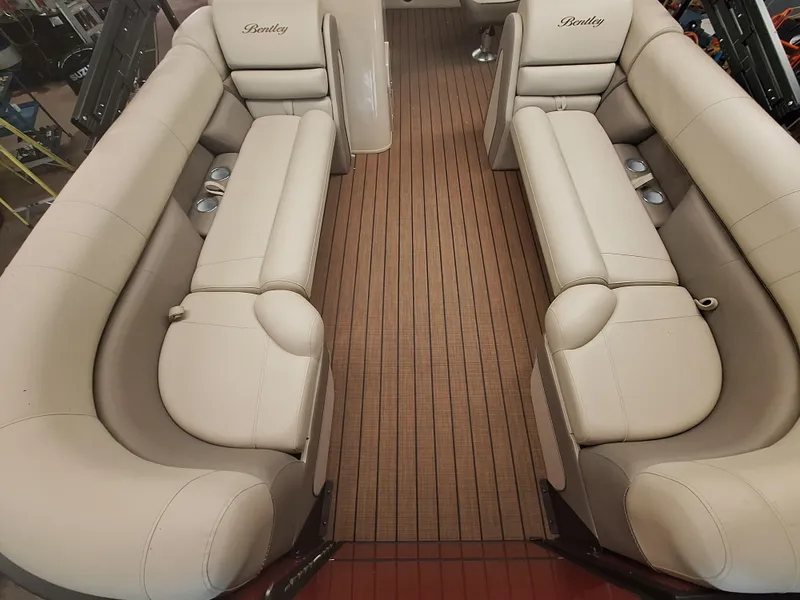 Slide: The Image of 2024 Bentley Pontoons Elite 253 SwingBack DC interior with beige seating and wooden flooring. - 5