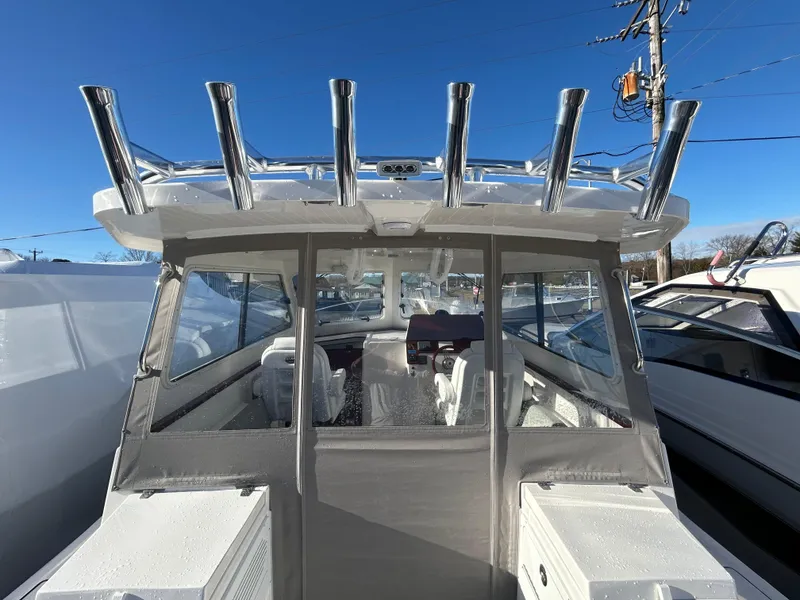 Slide: The Image of 2024 NorthCoast 315HT boat with rod holders, viewed from the rear on a sunny day. - 16