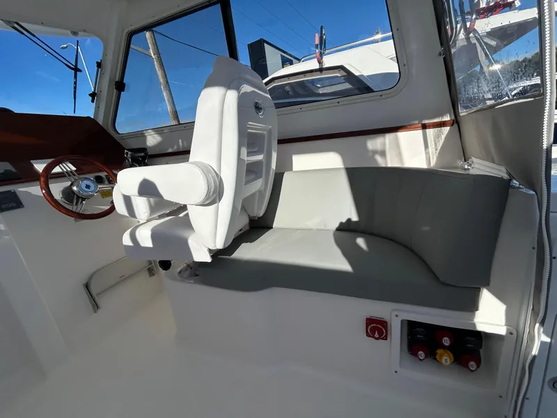 Slide: The Image of 2024 NorthCoast 315HT boat interior with helm seat and curved bench. - 17