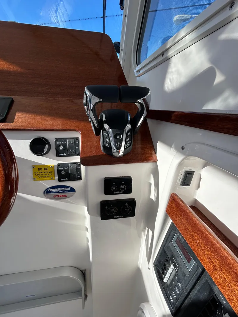 Slide: The Image of 2024 NorthCoast 315HT helm controls with Yamaha systems and wood accents. - 21