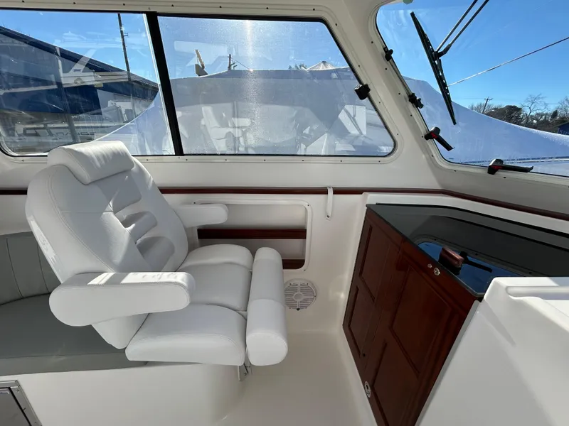 Slide: The Image of 2024 NorthCoast 315HT boat interior with white seating and wooden cabinetry. - 23