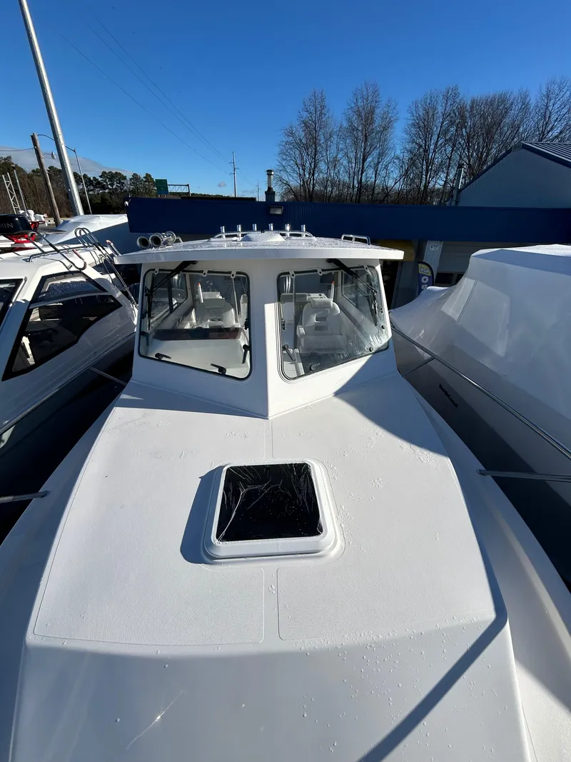 Slide: The Image of 2024 NorthCoast 315HT boat, white exterior, docked under clear blue sky. - 32