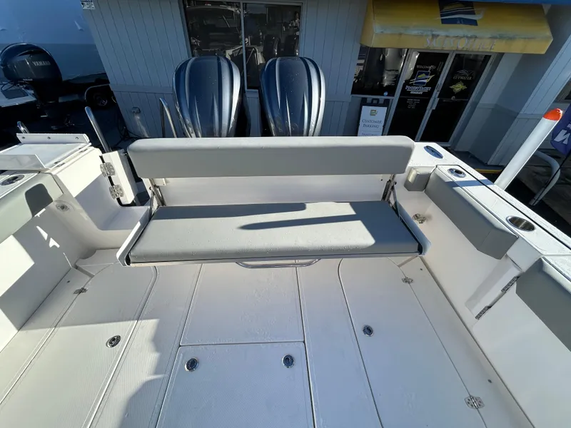 Slide: The Image of 2024 NorthCoast 315HT boat interior with foldable bench seat and dual outboard motors. - 7