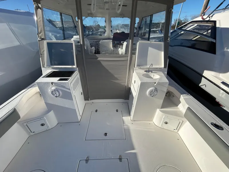 Slide: The Image of 2024 NorthCoast 315HT boat interior with seating, sink, and storage compartments. - 8