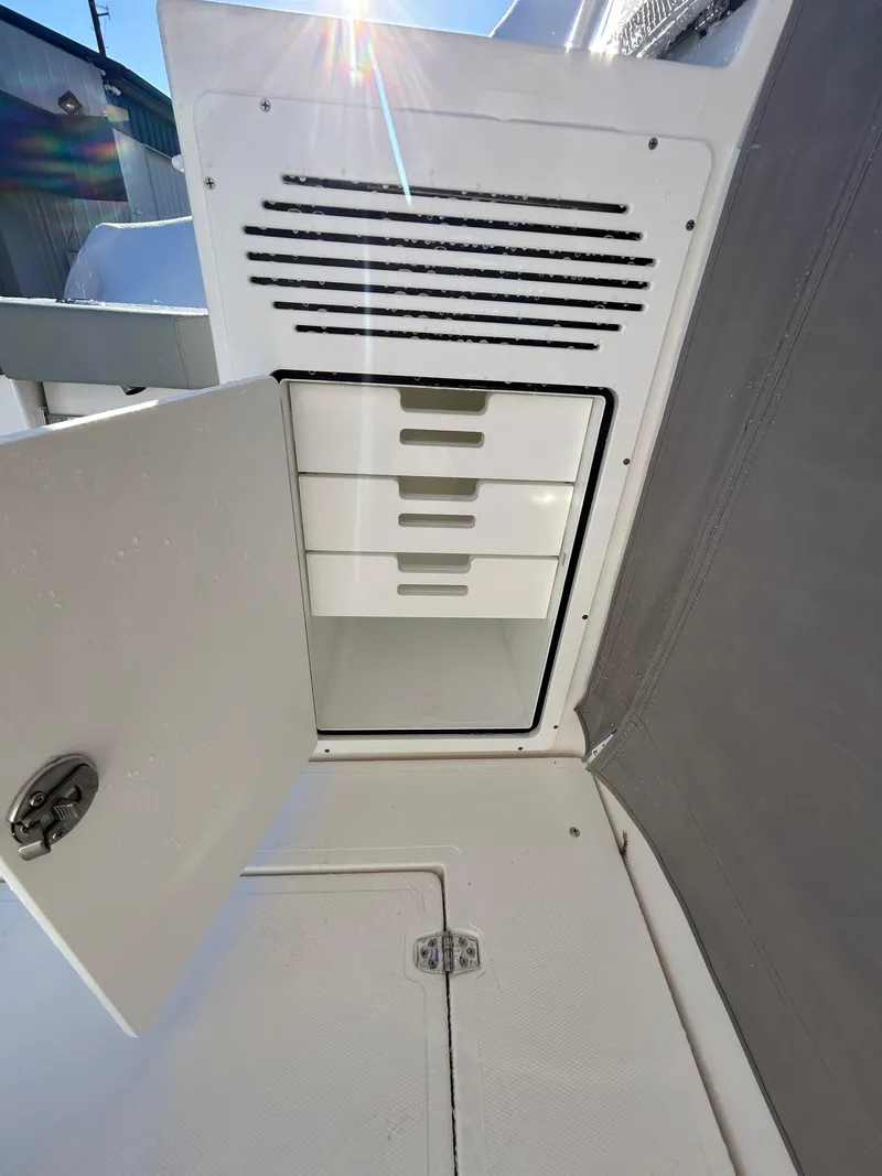 Slide: The Image of 2024 NorthCoast 315HT boat storage compartment with open door and drawers. - 9