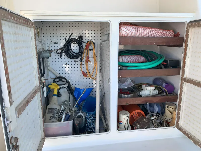 Slide: The Image of Storage cabinet on a 1986 Gladding Hearn Hunt Designed 60 boat with various tools and supplies. - 15