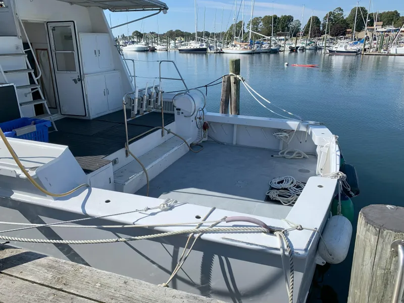 Slide: The Image of 1986 Gladding Hearn Hunt Designed 60 docked at a marina, empty deck, ropes, and calm water. - 3