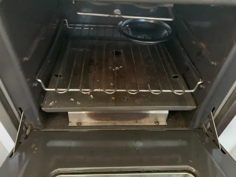 Slide: The Image of Interior of a used oven with metal racks and a drip tray. - 45