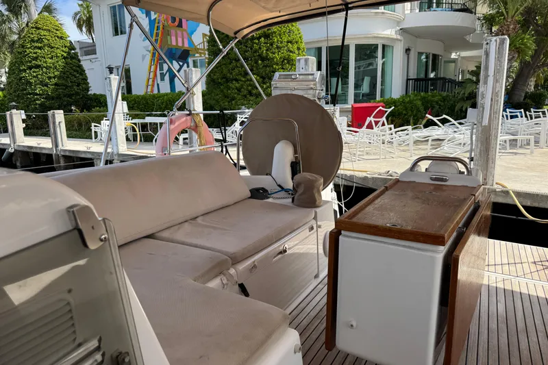 Slide: The Image of 2018 Jeanneau Sun Odyssey 440 yacht interior with seating and table, docked near modern building. - 12