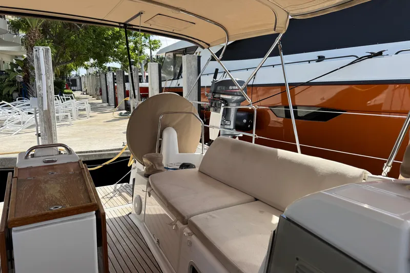 Slide: The Image of Jeanneau Sun Odyssey 440 yacht cockpit with seating, docked beside a large boat. - 13