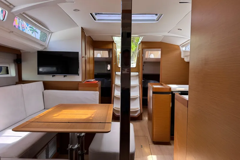 Slide: The Image of Interior of 2018 Jeanneau Sun Odyssey 440 yacht with modern wood finish and seating area. - 19