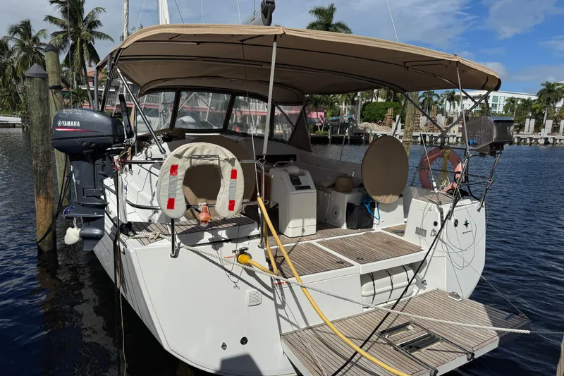Slide: The Image of 2018 Jeanneau Sun Odyssey 440 docked, featuring Yamaha motor and spacious deck. - 2