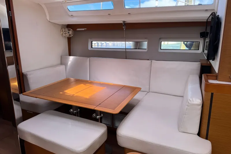 Slide: The Image of Interior of 2018 Jeanneau Sun Odyssey 440 yacht with white seating and wooden table. - 21