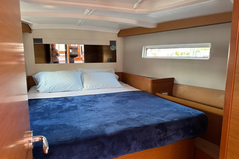 Slide: The Image of Cozy cabin interior of 2018 Jeanneau Sun Odyssey 440 sailboat with blue bedding. - 30