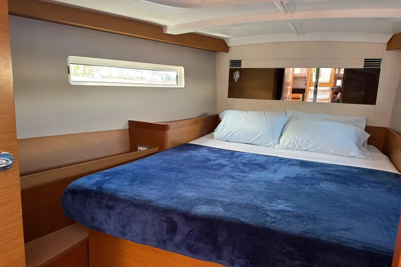 Slide: The Image of Cozy cabin interior of 2018 Jeanneau Sun Odyssey 440 with plush bedding and wooden accents. - 31