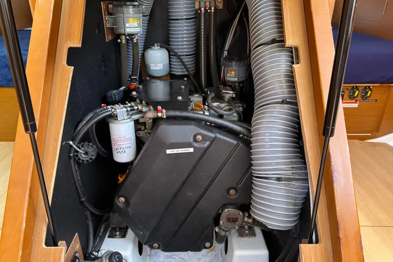 Slide: The Image of Engine compartment of 2018 Jeanneau Sun Odyssey 440 sailboat, showcasing mechanical components and hoses. - 36