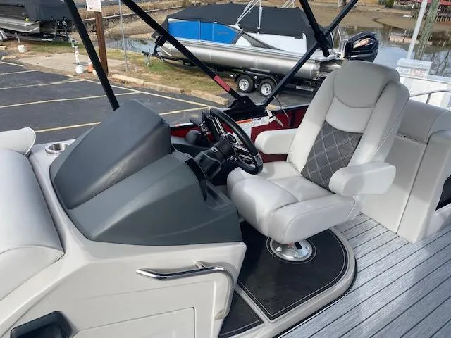 Slide: The Image of 2024 SunCatcher Elite 324 SS boat helm with luxurious captain's chair and modern dashboard. - 21