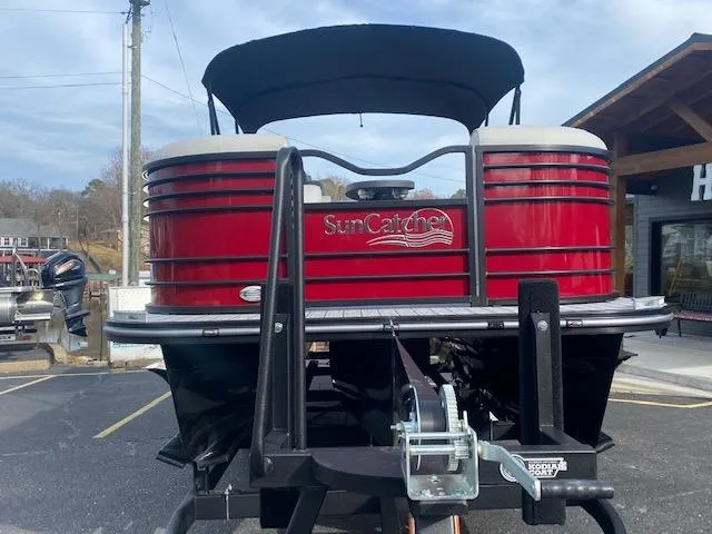 Slide: The Image of 2024 SunCatcher Elite 324 SS pontoon boat in red, front view. - 3
